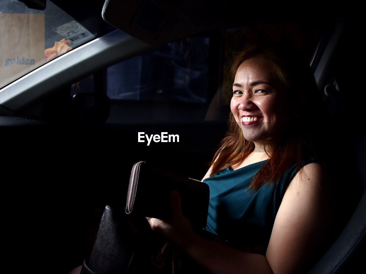 Portrait of woman smiling while sitting in car