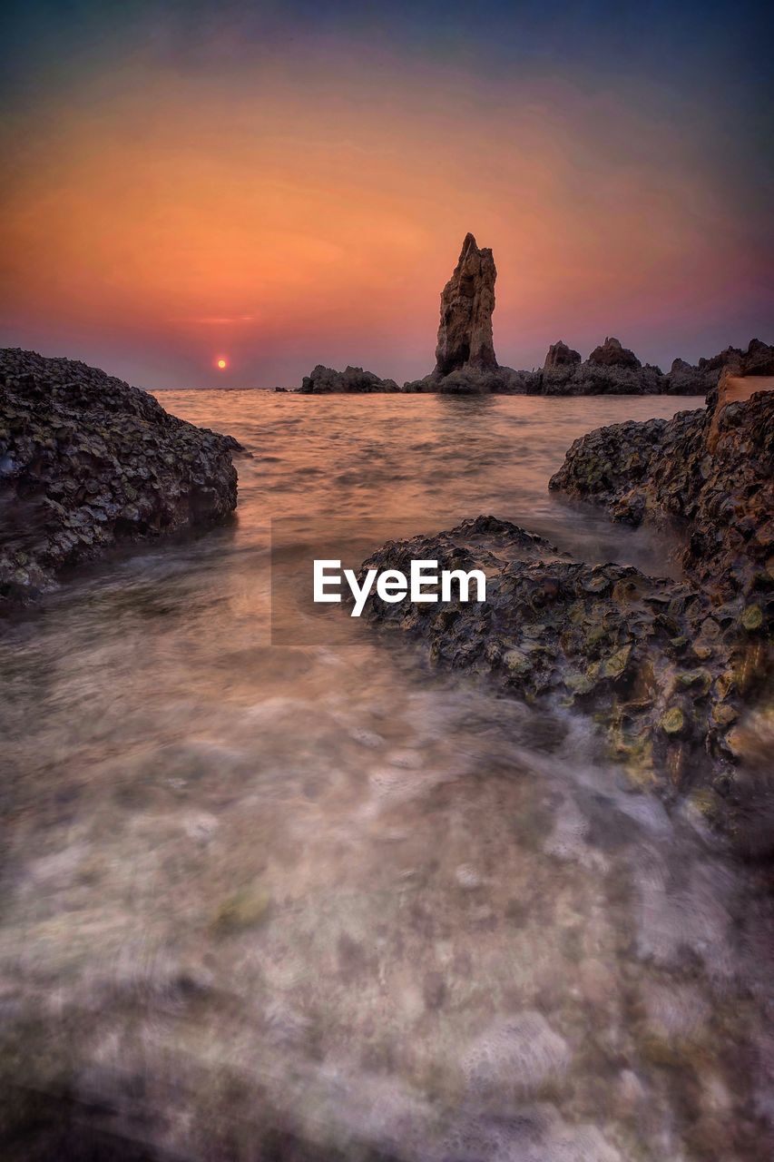 SCENIC VIEW OF ROCKS AT SUNSET