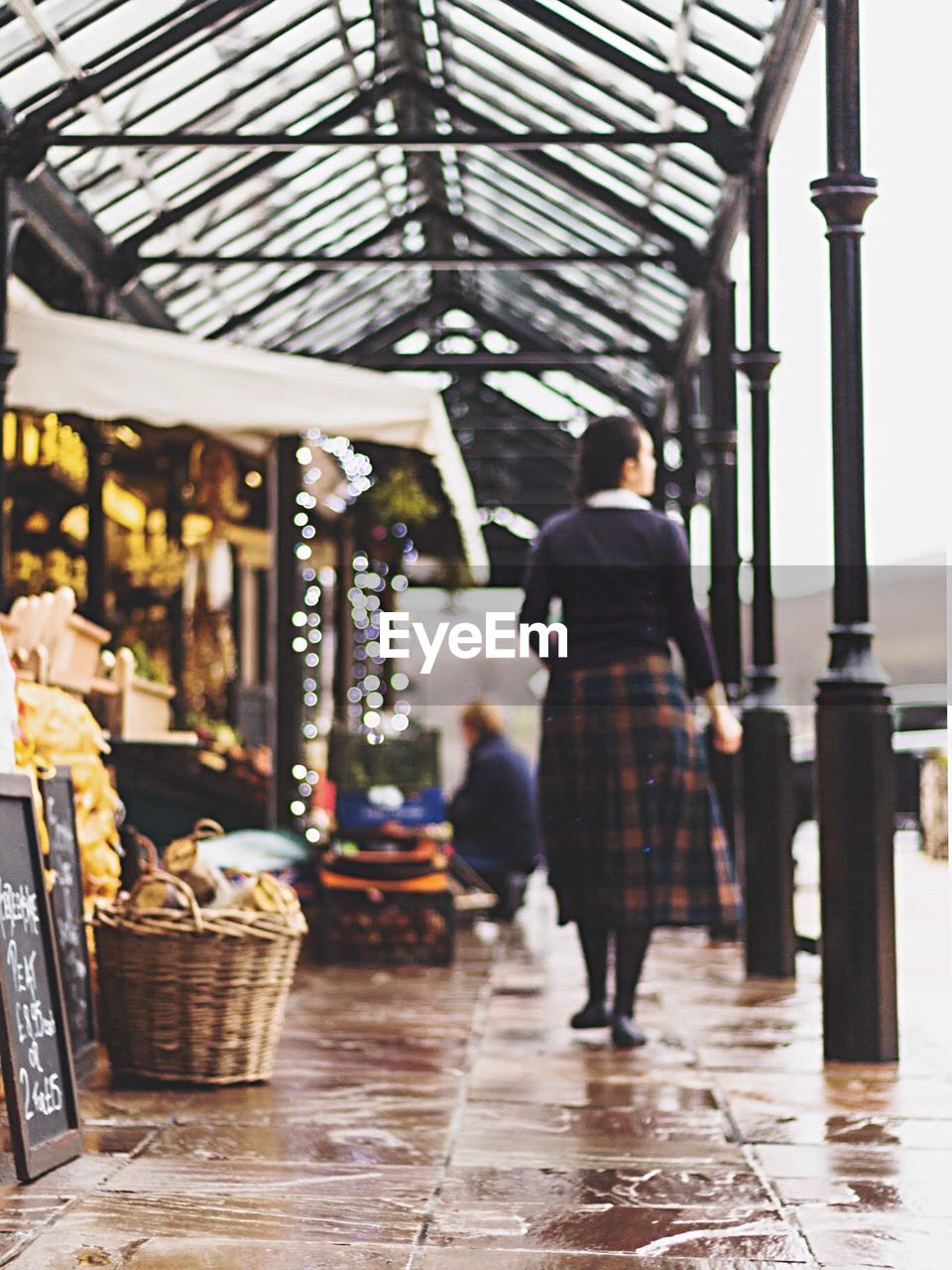 Rear view of woman walking in market