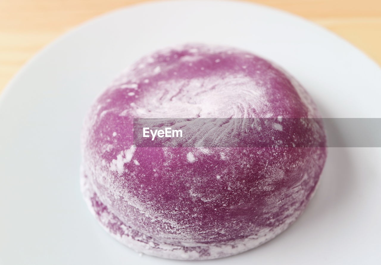 Closeup of delectable japanese purple sweet potato daifuku with red bean paste filling