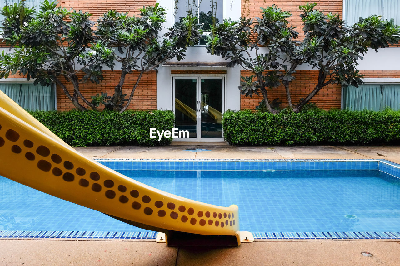 CLOSE-UP OF YELLOW HOUSE AGAINST TREE