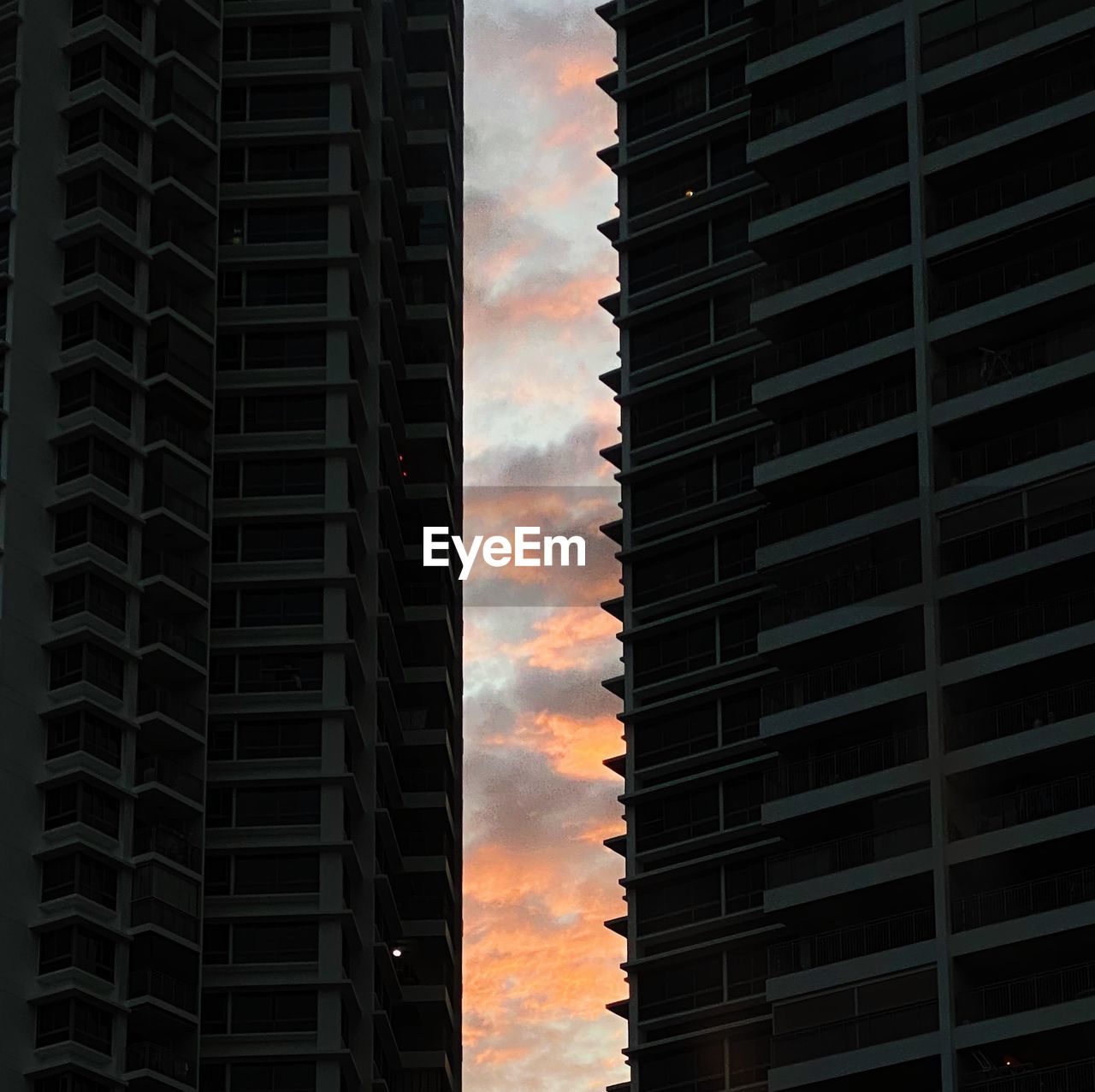 LOW ANGLE VIEW OF BUILDINGS AGAINST SKY AT SUNSET