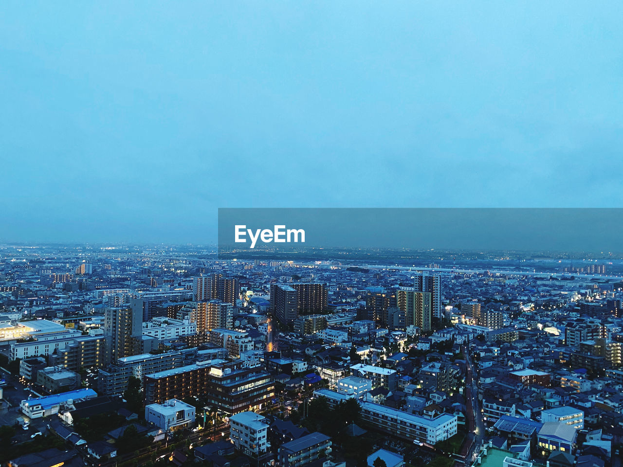 HIGH ANGLE VIEW OF ILLUMINATED BUILDINGS AGAINST SKY