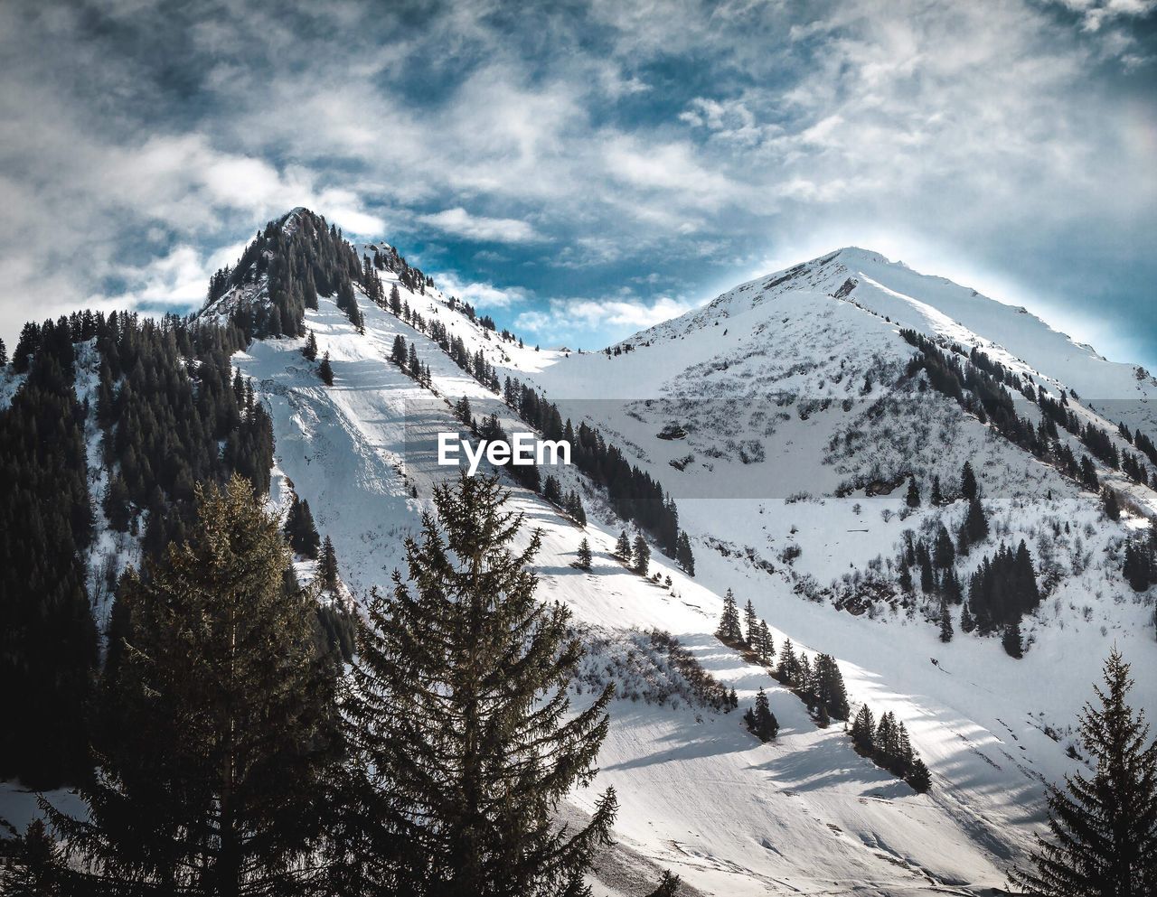 Scenic view of snowcapped mountain against cloudy sky