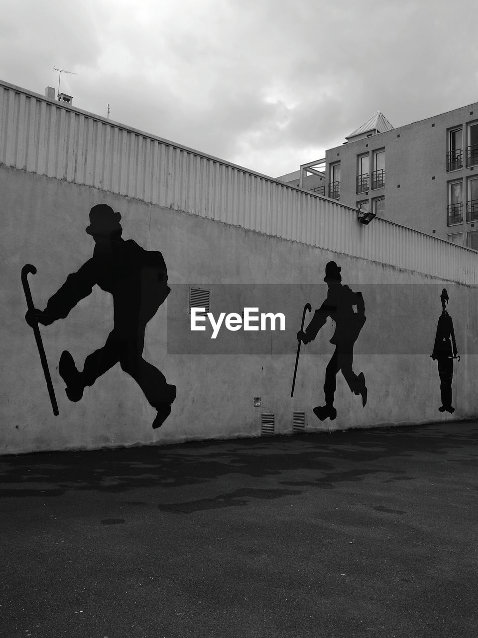 MEN JUMPING ON WALL AGAINST SKY