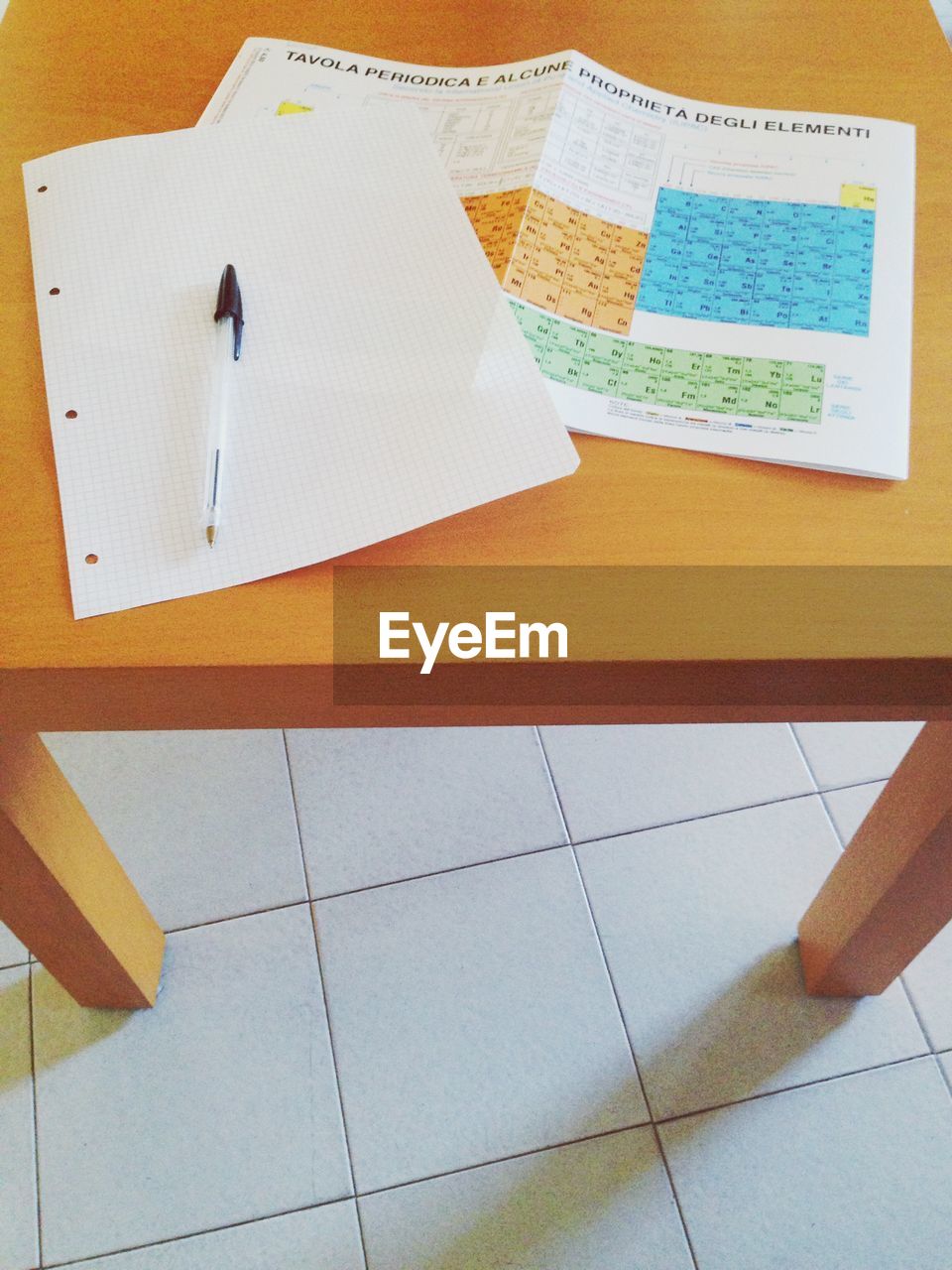 Periodic chart with pen and blank paper on table