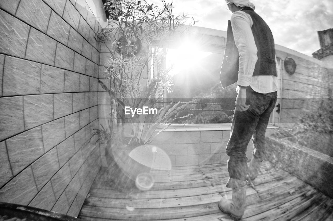 white, black, black and white, one person, full length, lens flare, monochrome photography, adult, lifestyles, men, monochrome, nature, leisure activity, architecture, sunlight, casual clothing, day, sky, sports, clothing, person, young adult, sunbeam, built structure, sports equipment, outdoors, footwear, skill, tree, skateboard, skateboard park, standing, fisheye lens, back lit, balance
