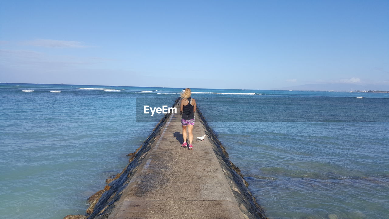 WOMAN ON SEA AGAINST SKY