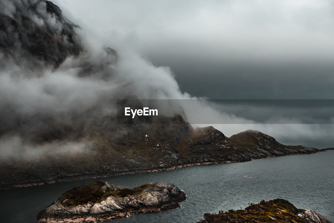 Scenic view of sea and mountain against sky