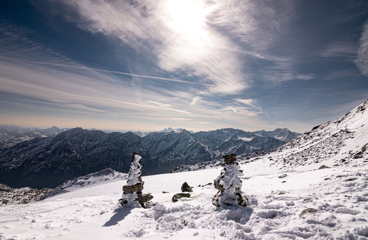 Rear view of man skiing on snow covered mountain against sky