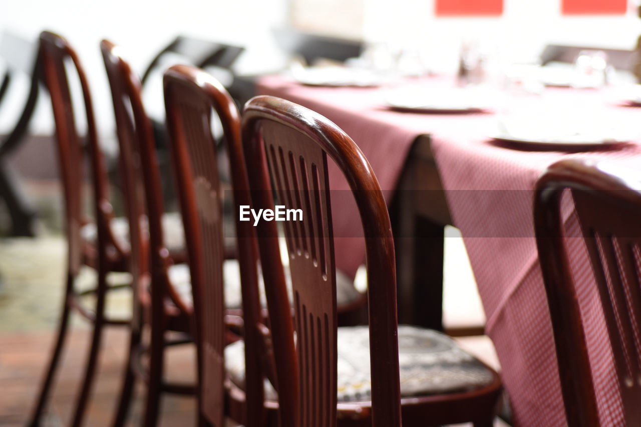 Close-up of empty chairs and table arranged in restaurant