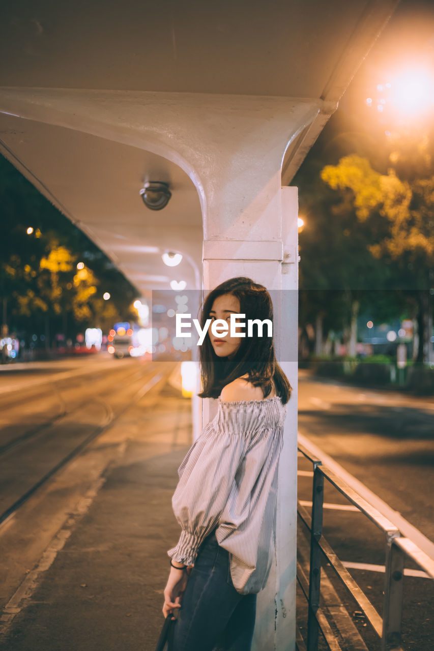 Portrait of young woman standing outdoors at night