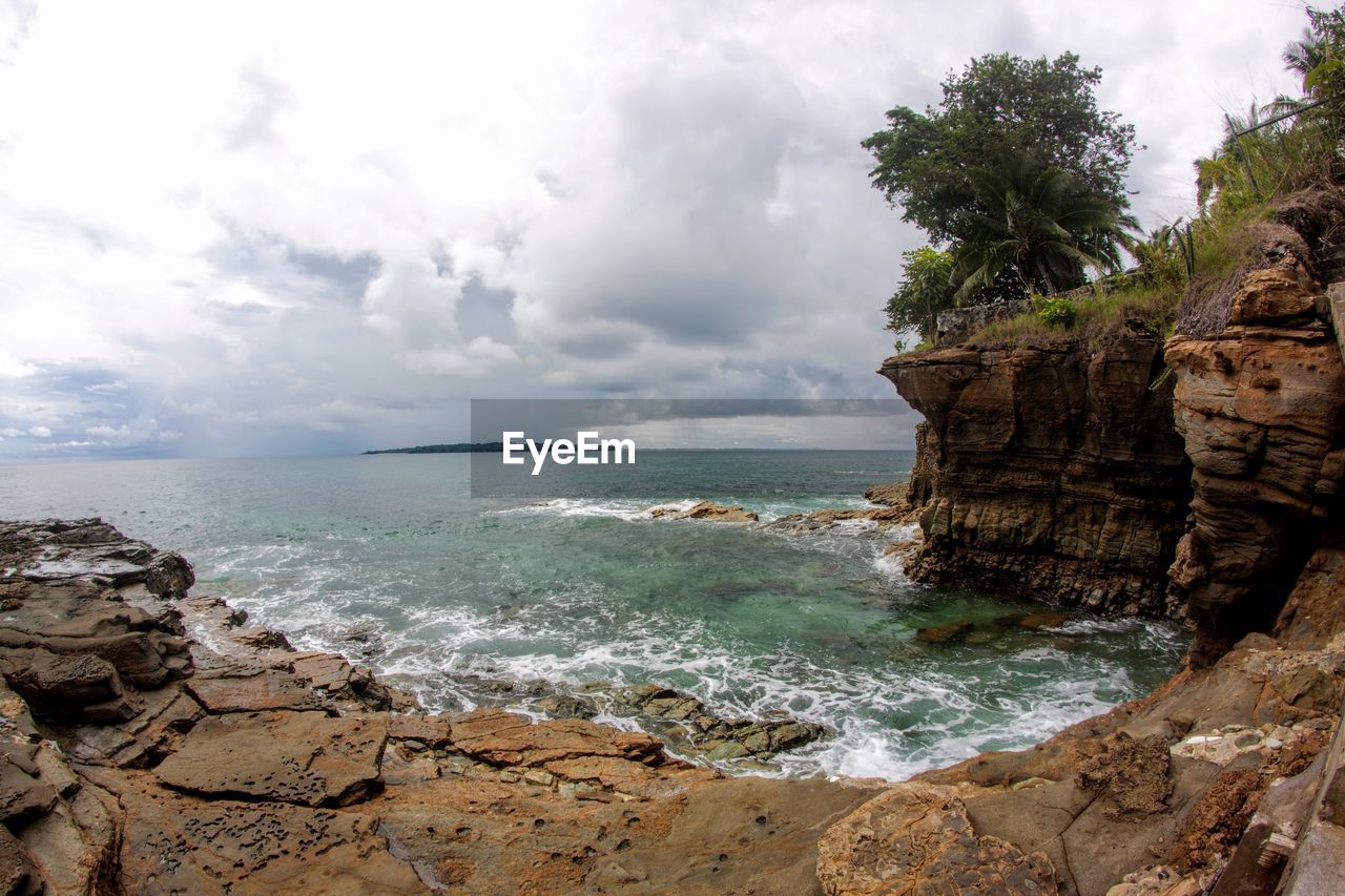 Scenic view of sea against sky with cliff 