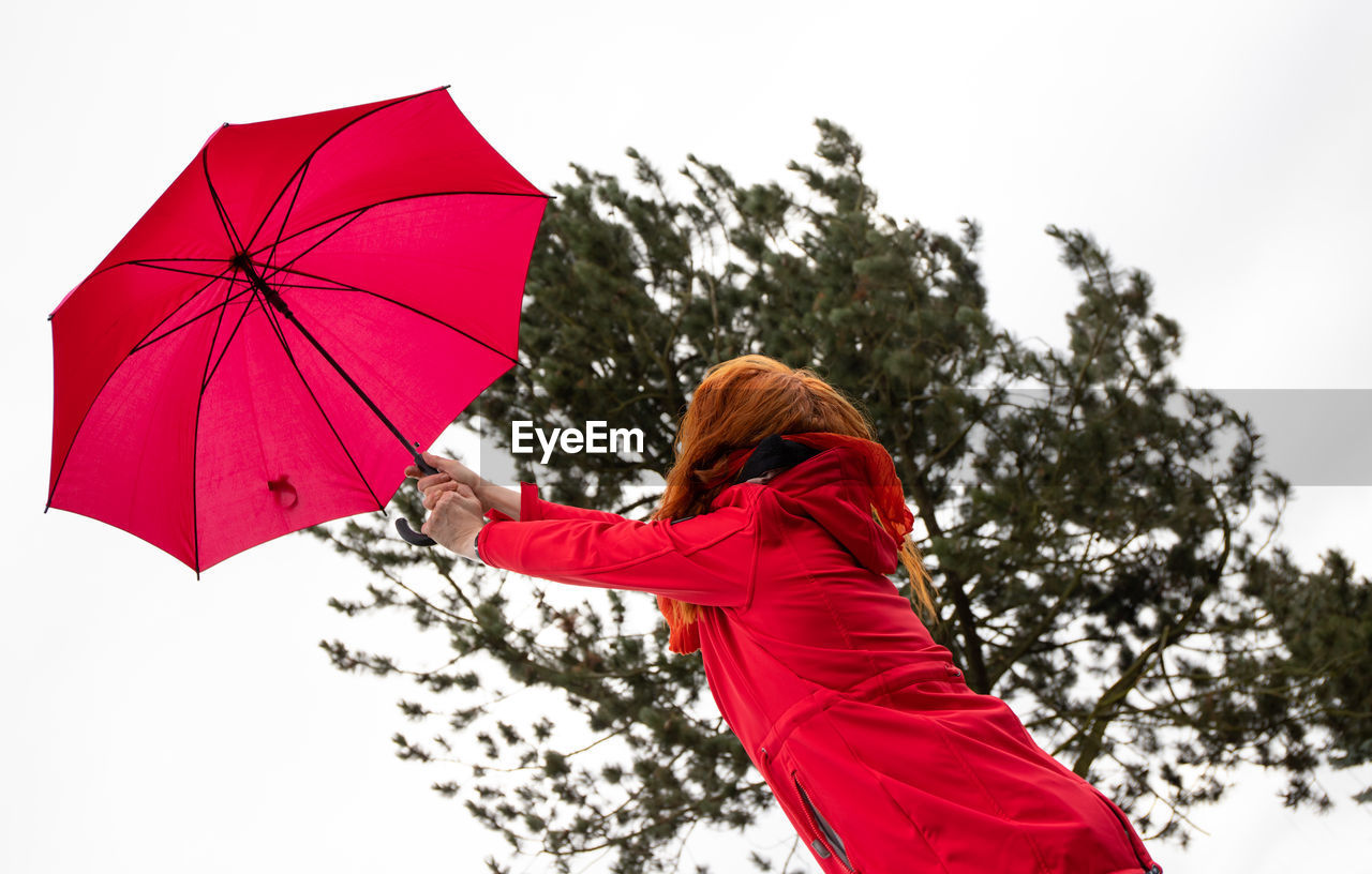 low angle view of man holding umbrella