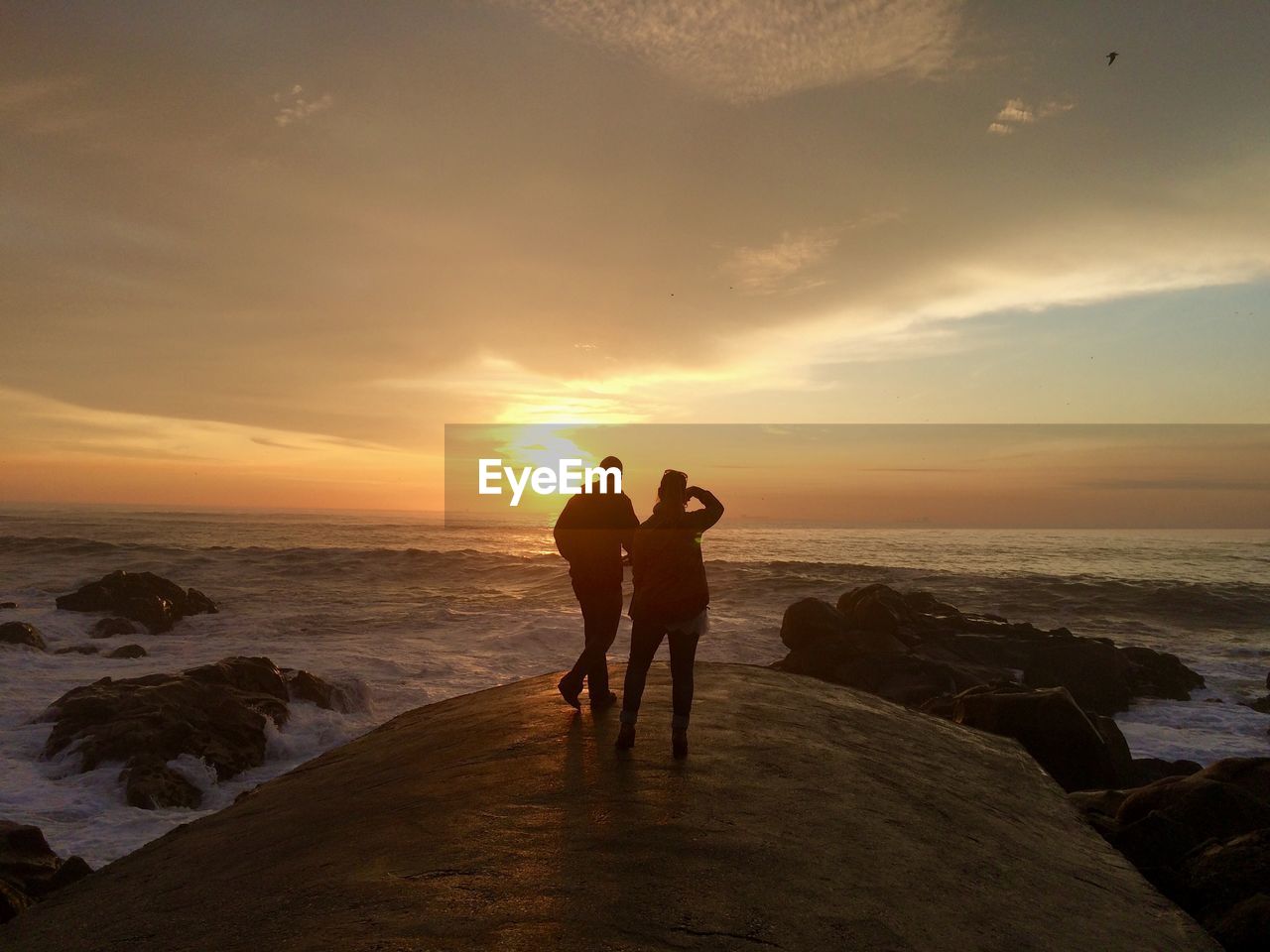 Silhouette of couple walking on beach