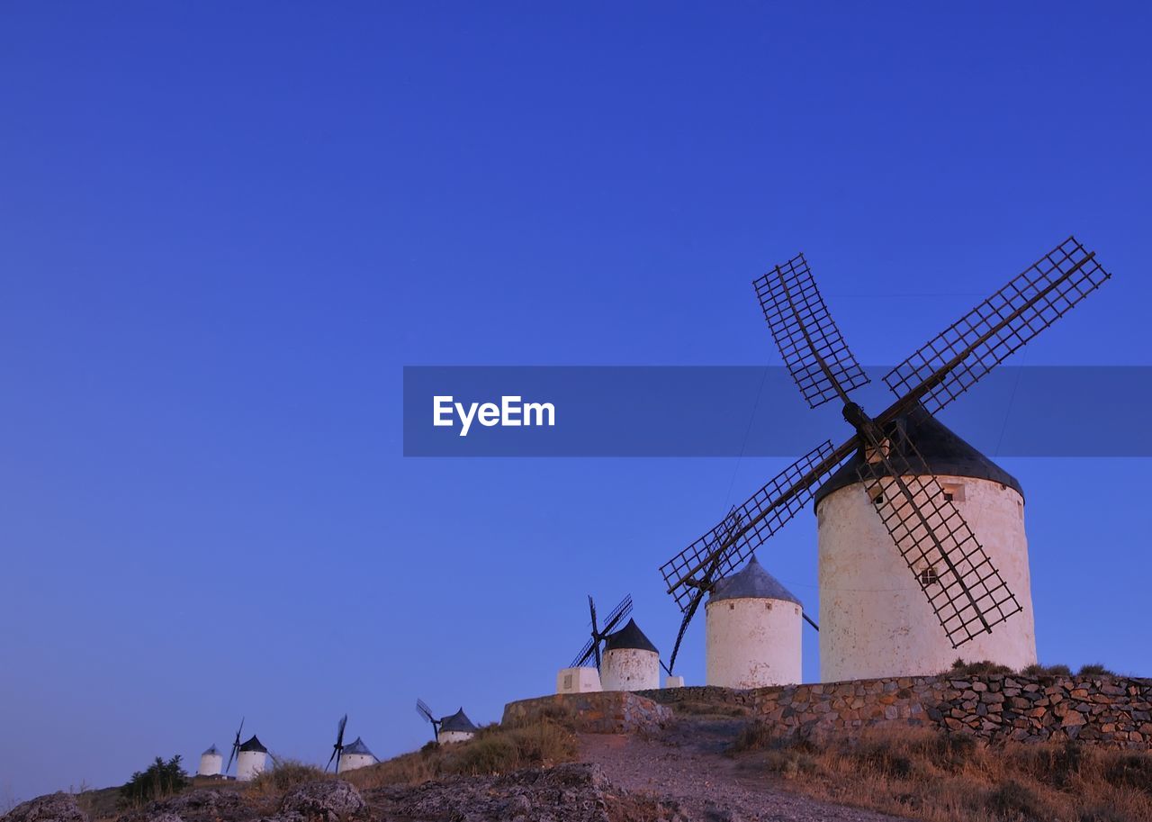 TRADITIONAL WINDMILL ON LANDSCAPE AGAINST CLEAR SKY