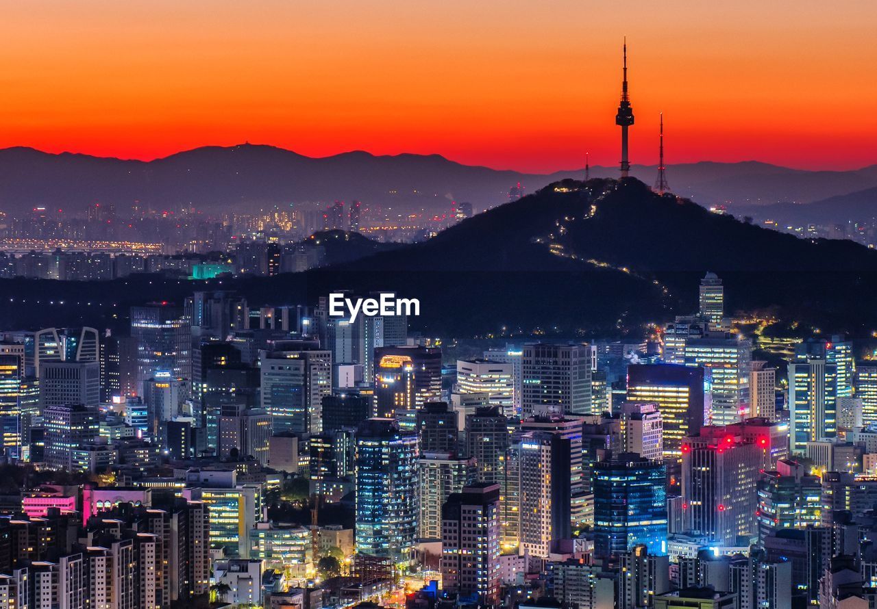 ILLUMINATED CITYSCAPE AGAINST SKY AT NIGHT