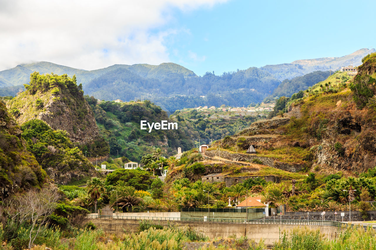 Scenic view of river and mountains against sky