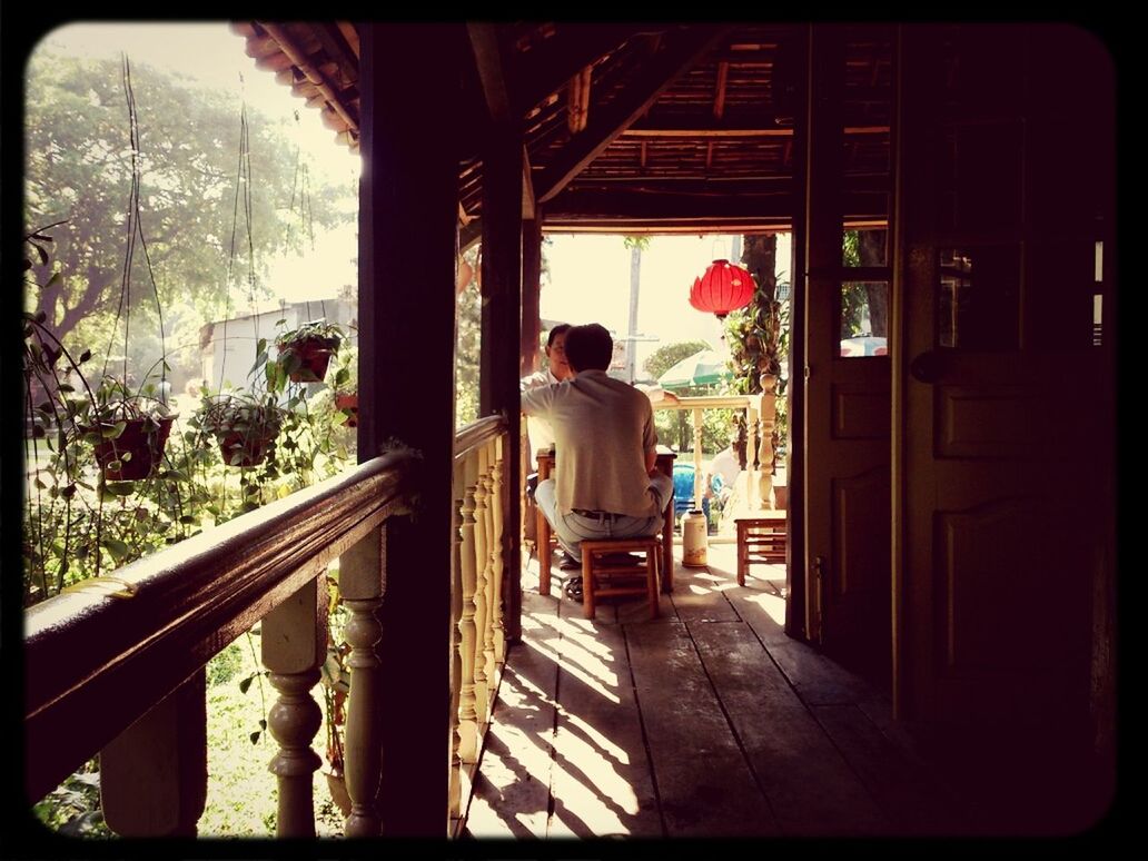 REAR VIEW OF MAN SEEN THROUGH WINDOW