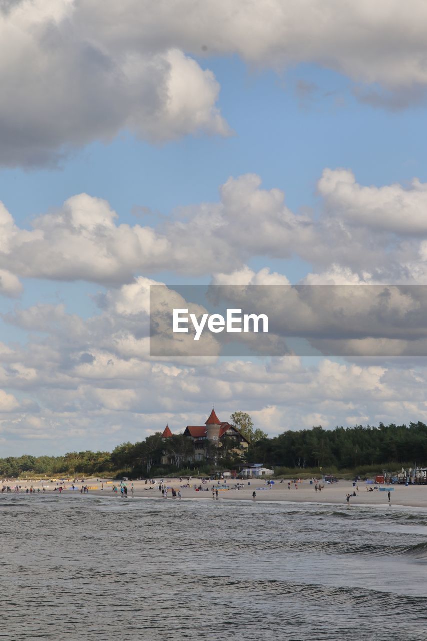 HOUSES ON BEACH AGAINST SKY
