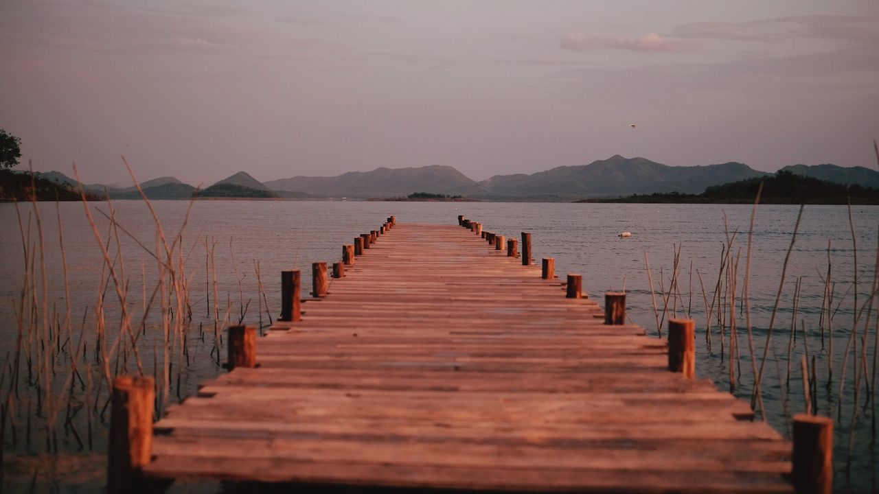 Wooden pier over sea against sky