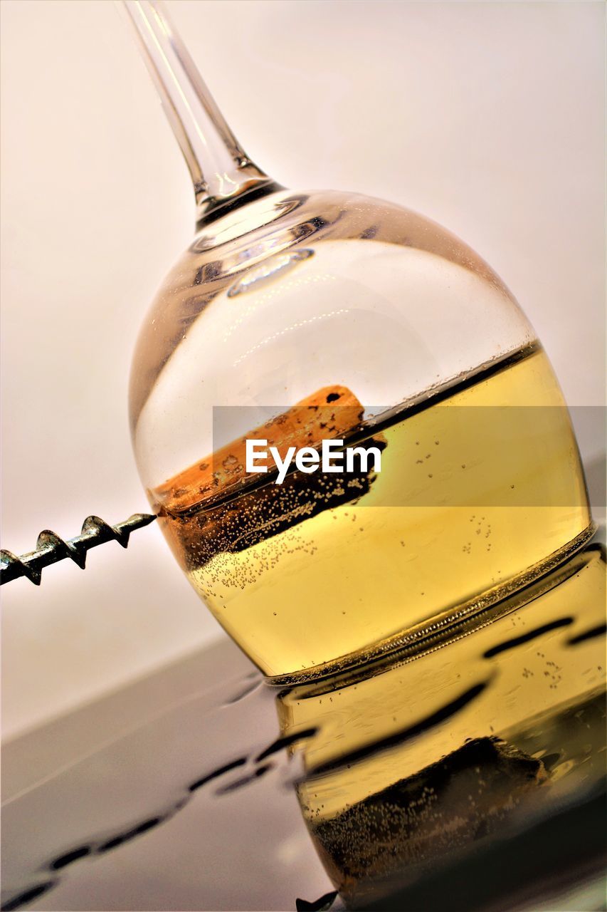 CLOSE-UP OF BEER GLASS ON TABLE AGAINST GRAY BACKGROUND