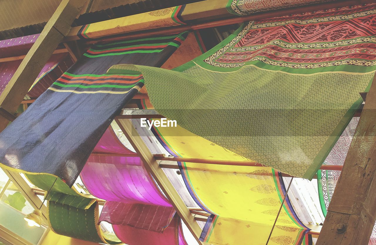 Low angle view of multi colored fabrics hanging from ceiling at cafe