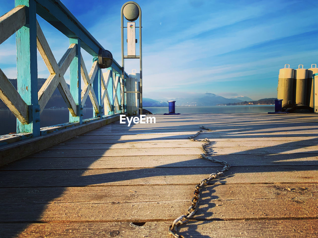 SHADOW OF BRIDGE ON FOOTPATH AGAINST BLUE SKY