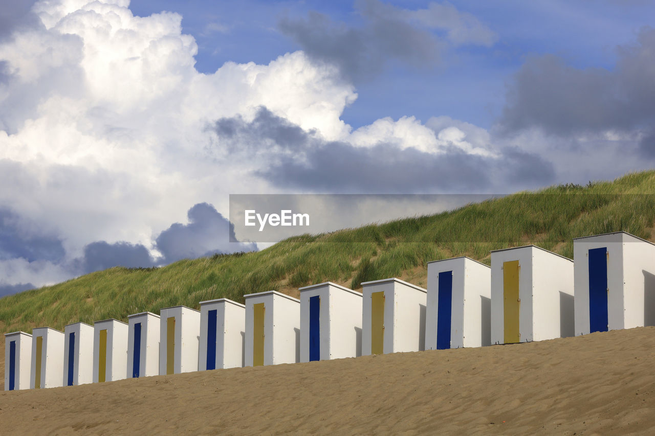 Row of beach huts with grassy dune in background