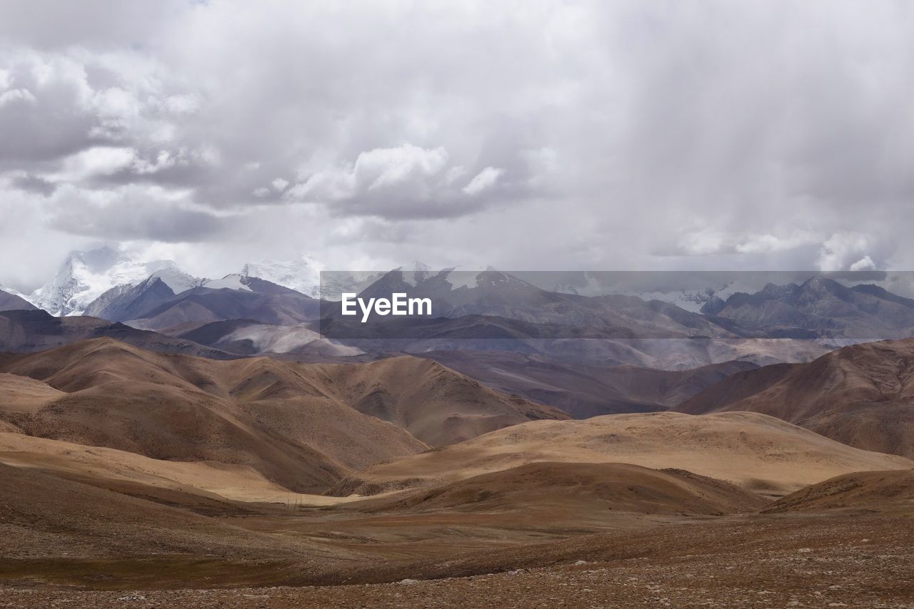 Scenic view of mountains against cloudy sky