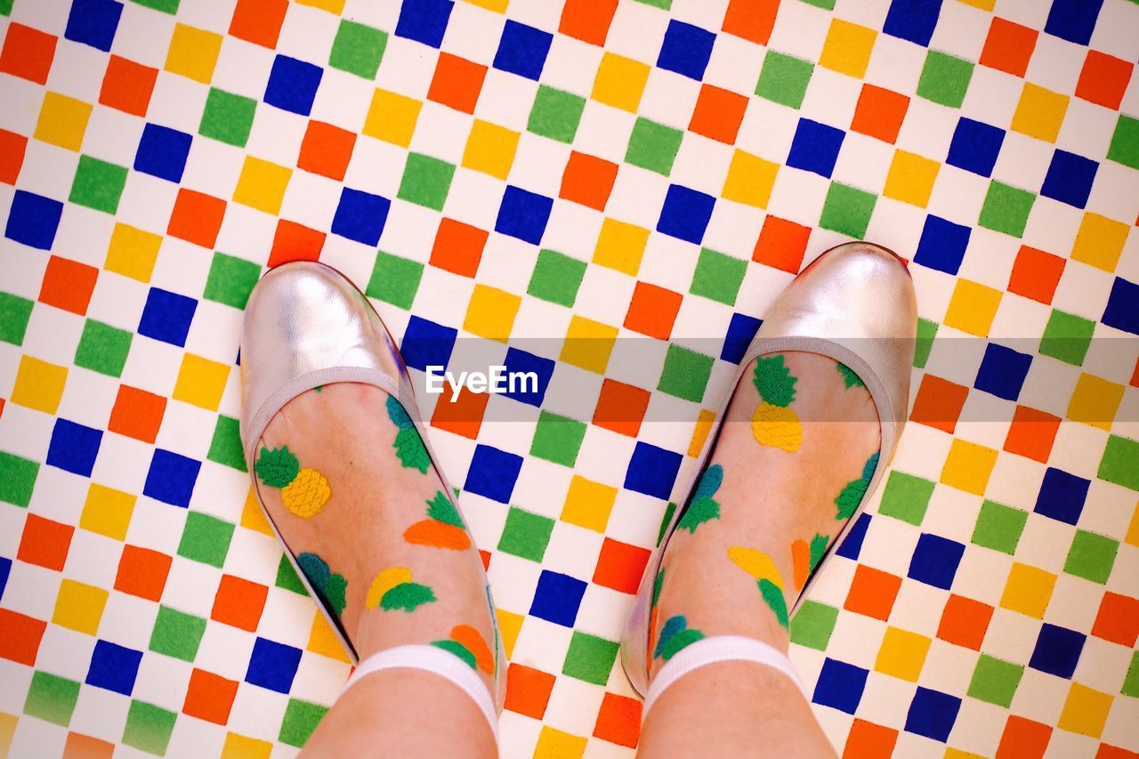 Low section of woman standing on colorful floor