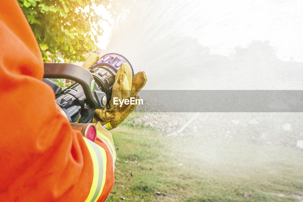 Close-up of firefighter extinguishing fire