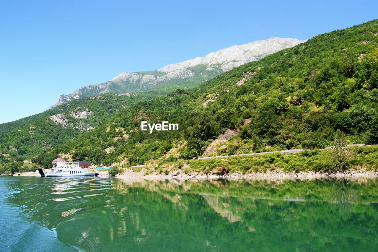 Scenic view of sea and mountains against clear sky