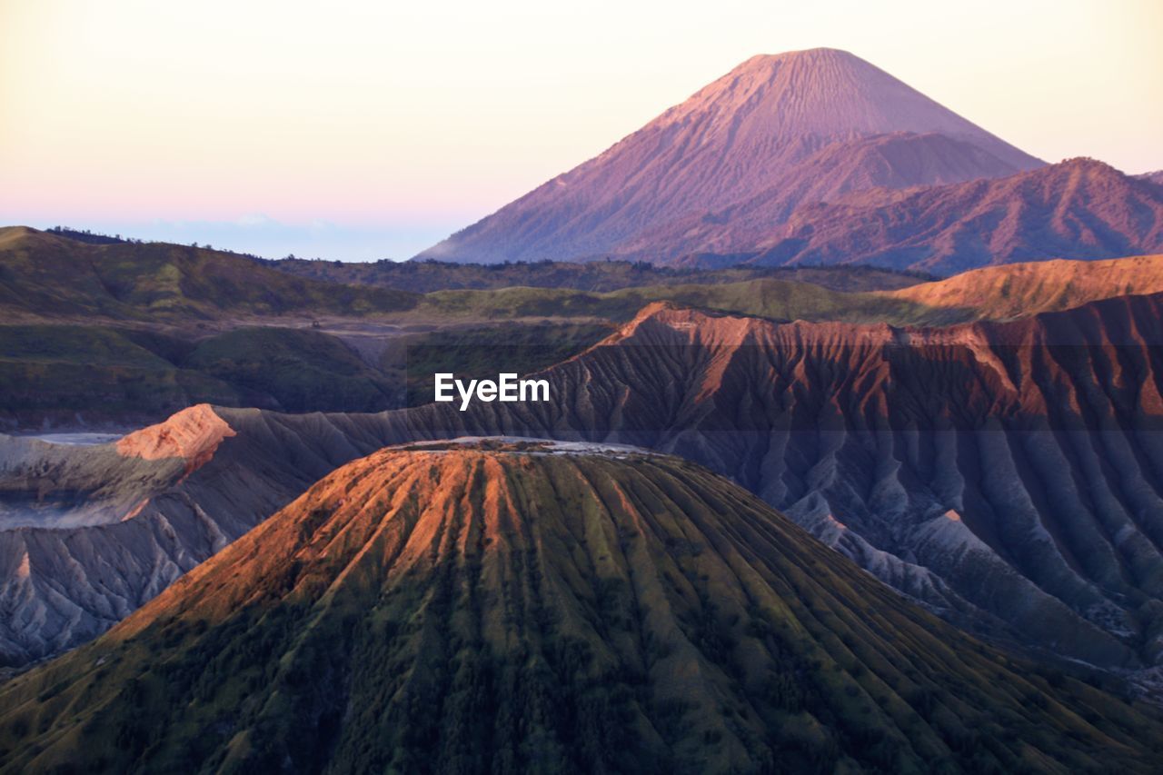 View of volcanic landscape against clear sky at sunset