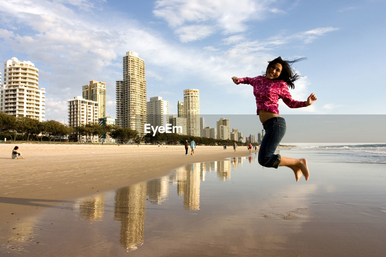 Full length of woman jumping at beach