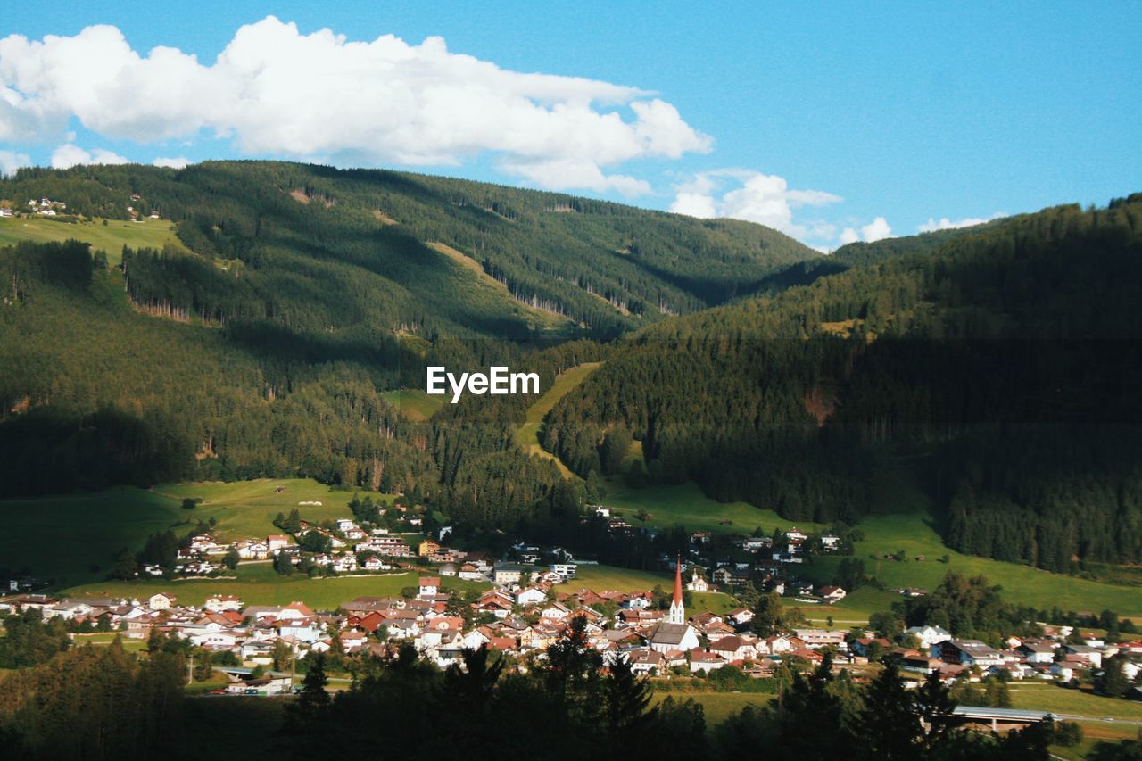 high angle view of townscape by mountains against sky