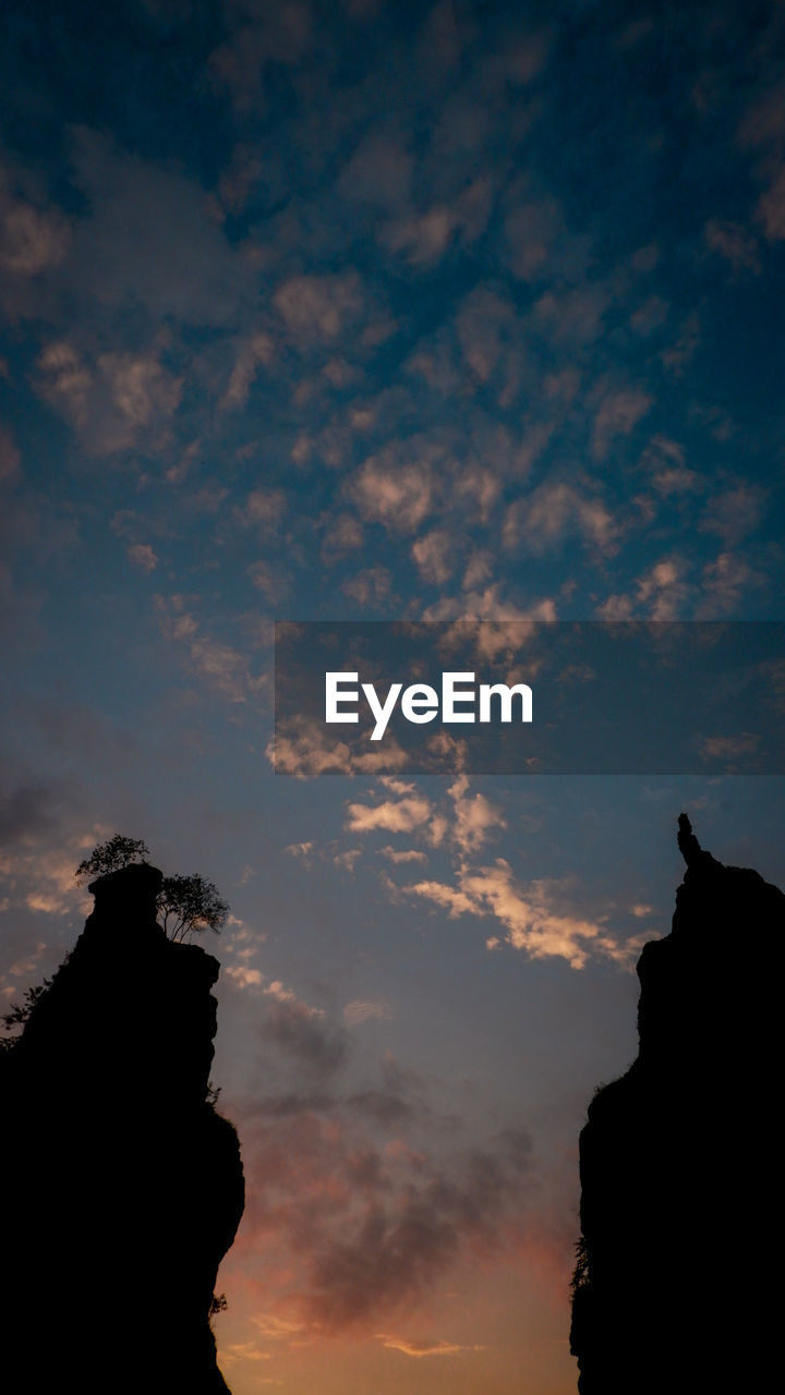 LOW ANGLE VIEW OF SILHOUETTE ROCK AGAINST SKY AT SUNSET