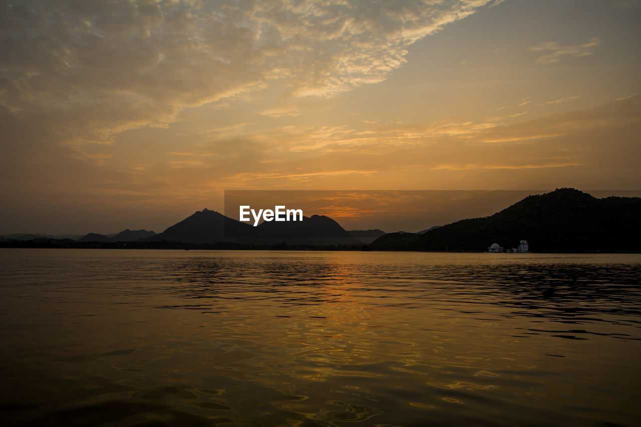 water, sky, mountain, scenics - nature, beauty in nature, reflection, sunset, horizon, cloud, sea, nature, tranquility, dusk, tranquil scene, evening, land, sunlight, no people, travel destinations, sun, environment, afterglow, mountain range, landscape, silhouette, outdoors, idyllic, travel, dramatic sky, coast, beach, ocean, bay, body of water