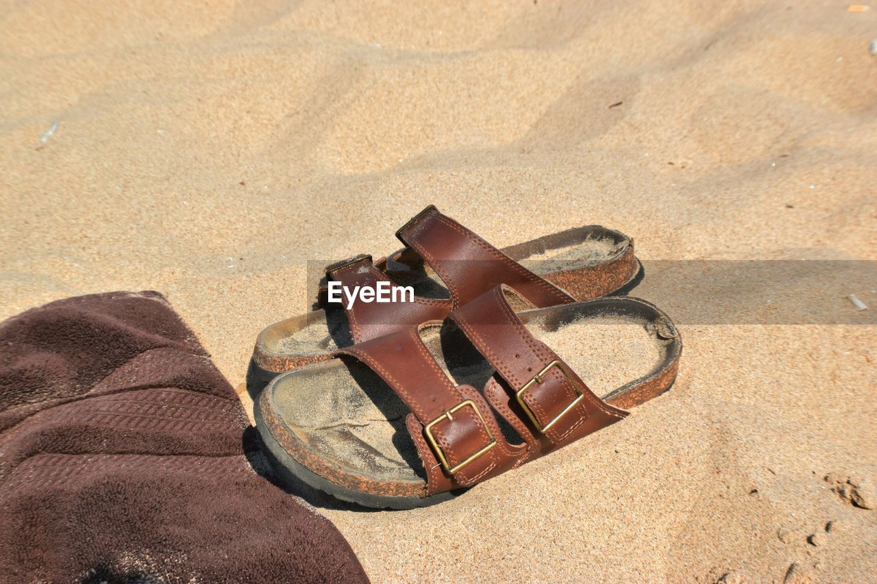 Sandals on sand during sunny day