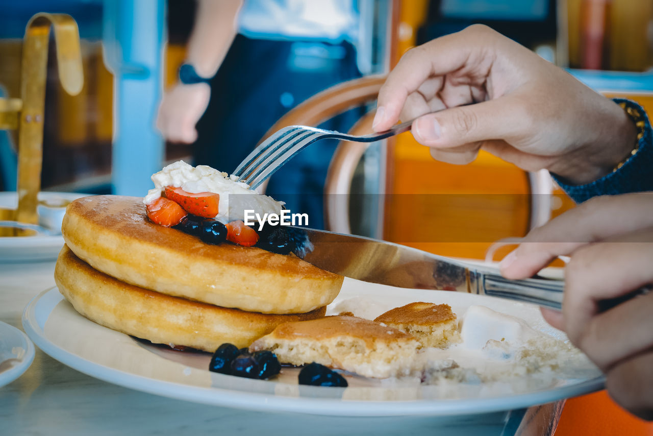 Close-up of person eating food in plate