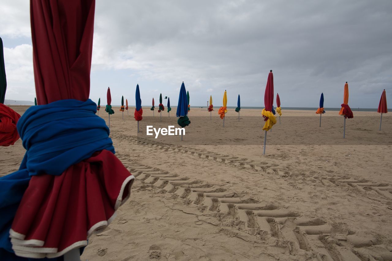 REAR VIEW OF BEACH UMBRELLAS ON SAND