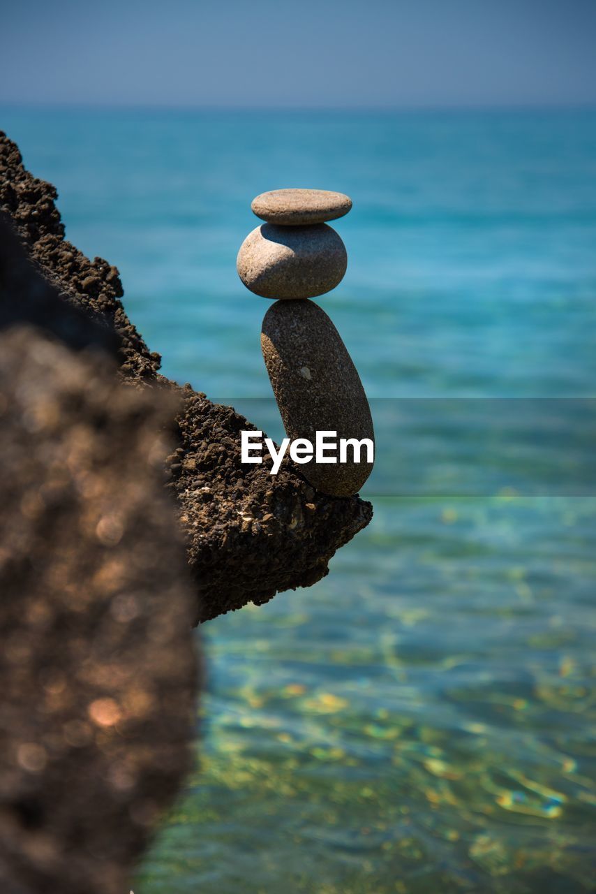 CLOSE-UP OF PEBBLES ON ROCK AT BEACH