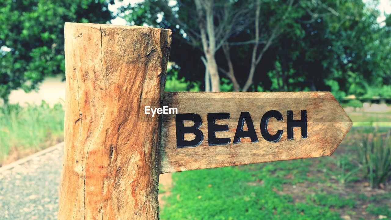 Close-up of beach text of wooden post