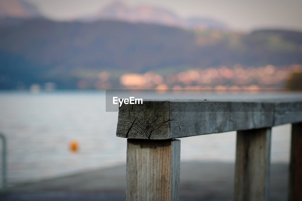 Close-up of wooden post at lake against sky