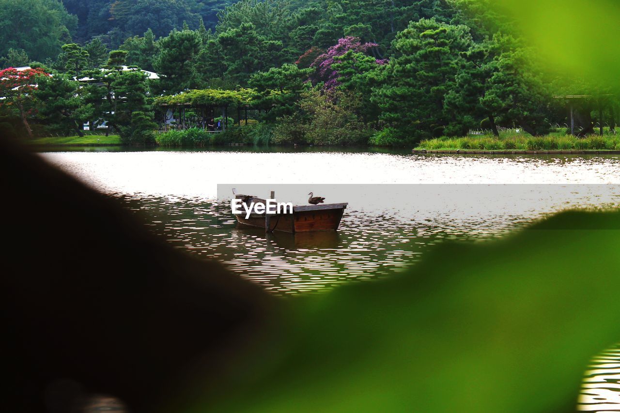 BOAT MOORED BY LAKE