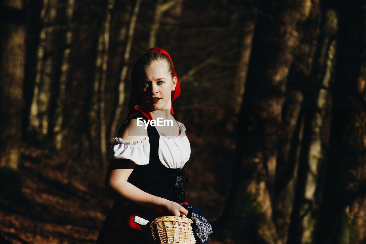 Portrait of woman in costume standing in forest