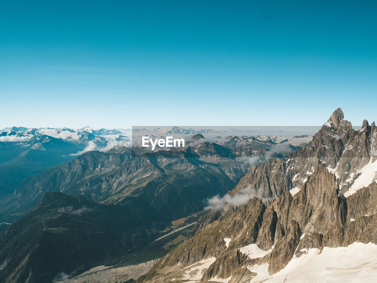 Scenic view of snowcapped mountains against clear blue sky