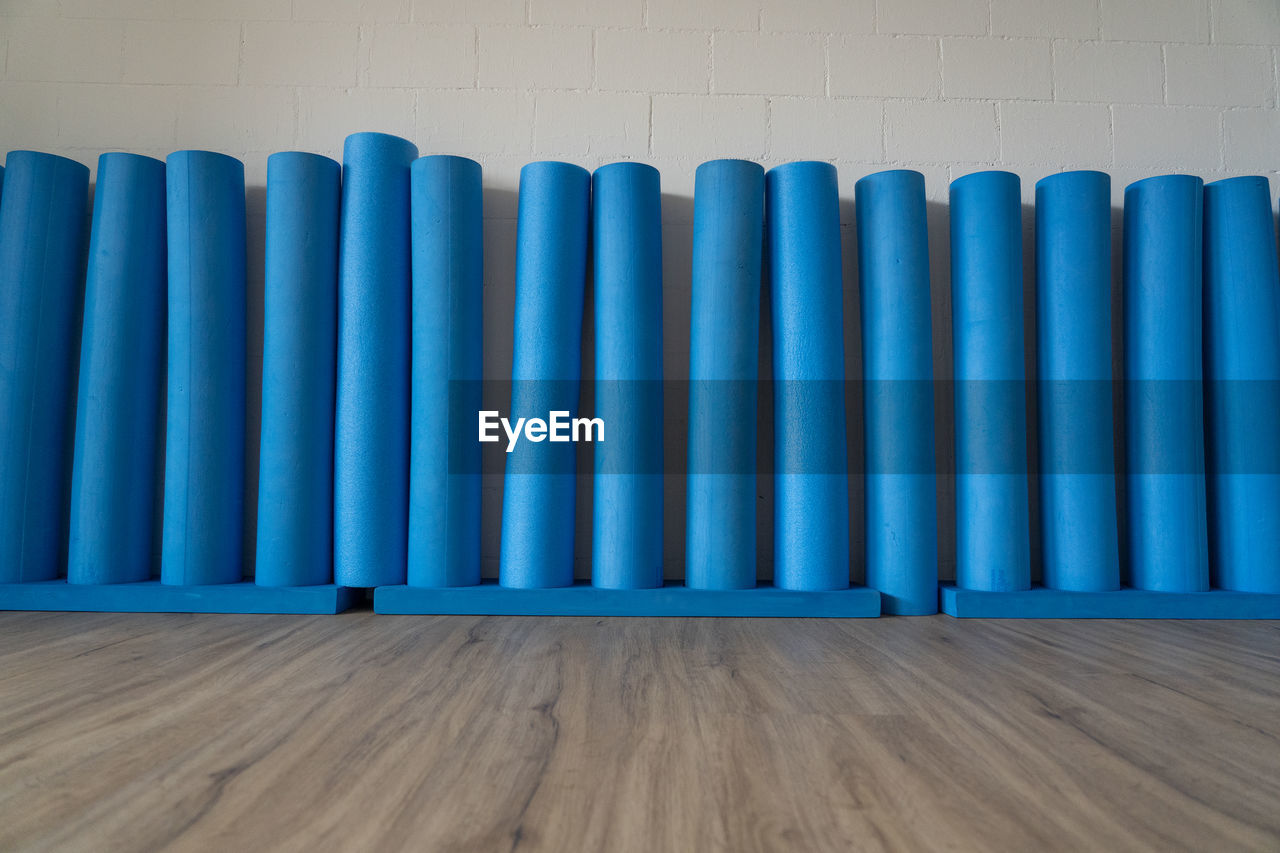  pilates rolls standing on wooden oak floor against the white brick wall. low angle view, concept.