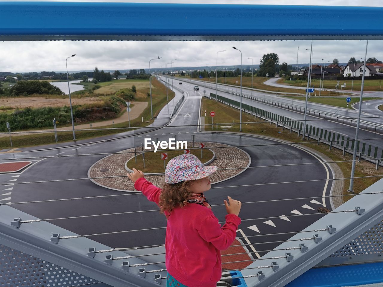 Rear view of girl standing on bridge