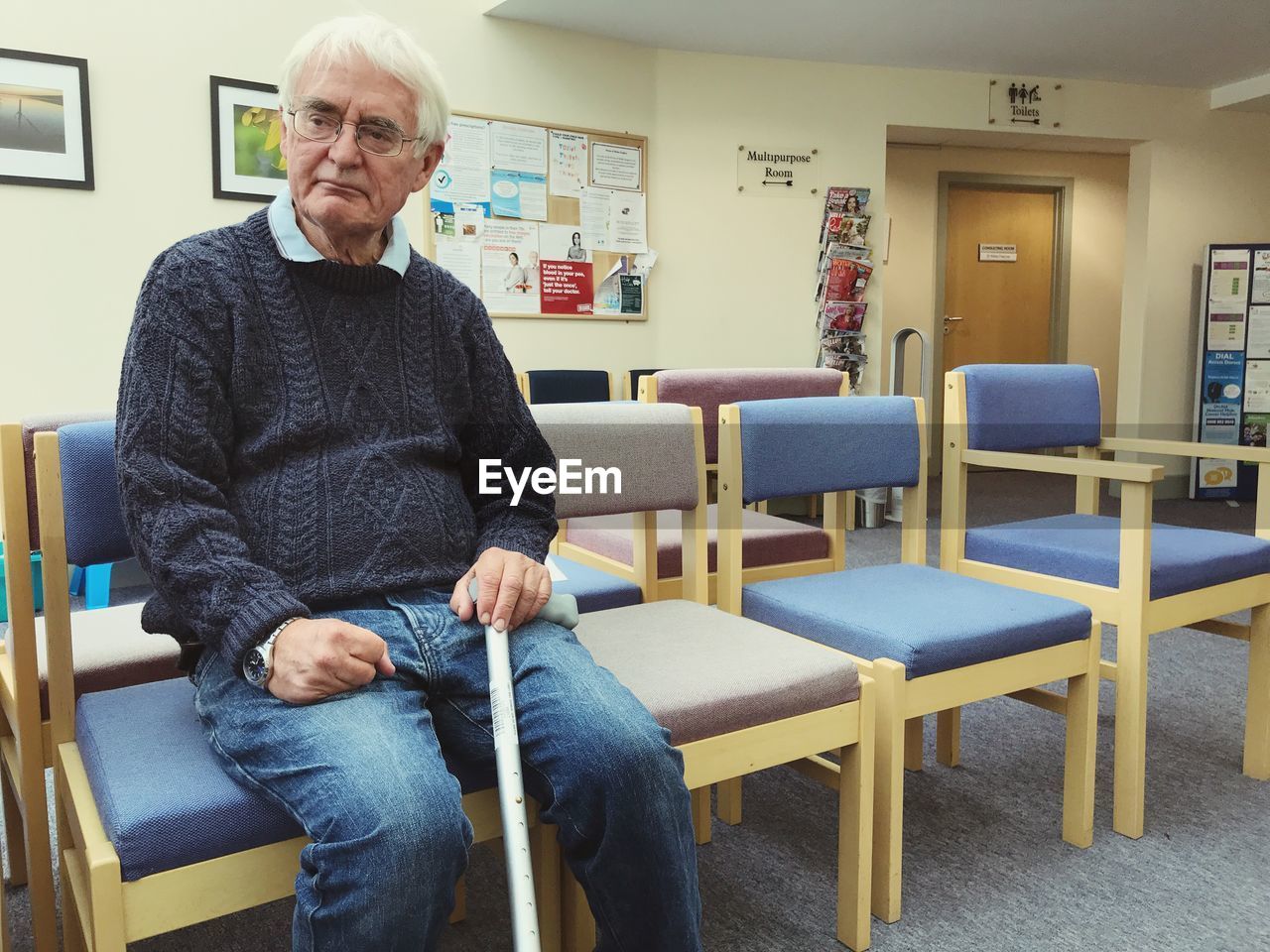 Thoughtful senior man sitting on chair in hospital